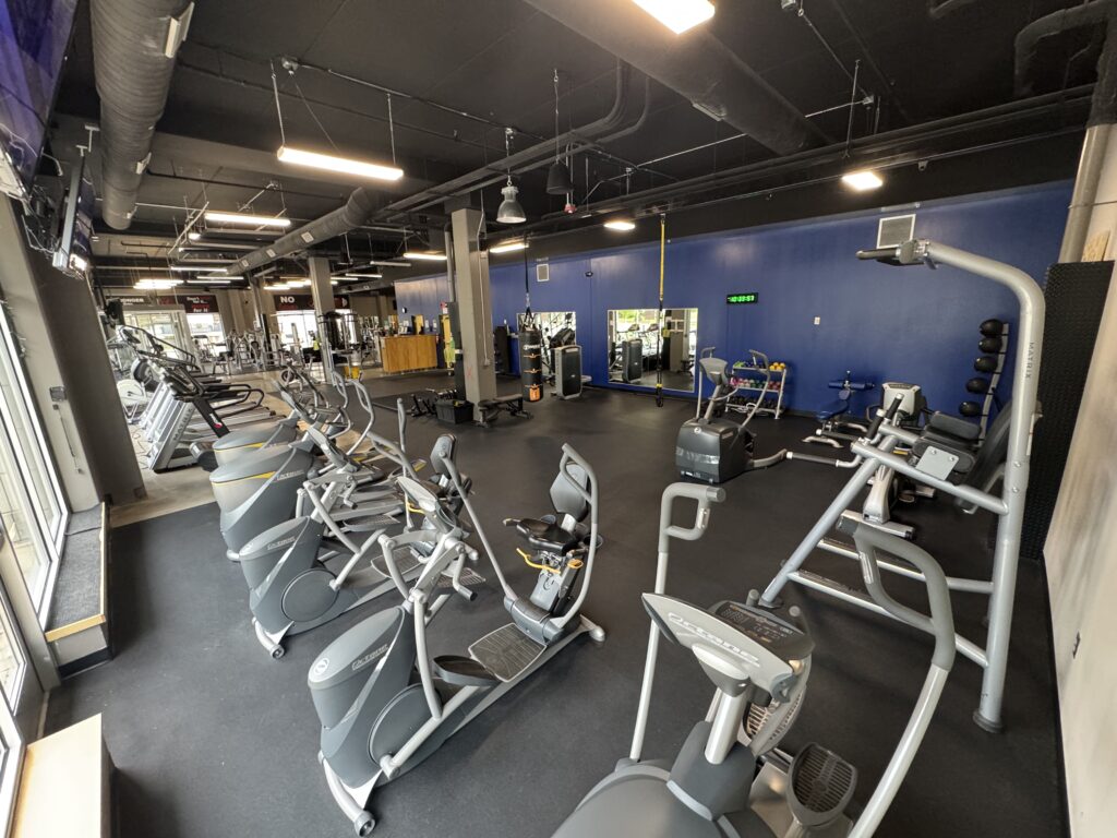 Treadmills, Bikes, Elliptical Machines, Stair Steppers, and Row Machine with TVs at Fifth Street Fitness Gym in Coralville, Iowa. From the corner.